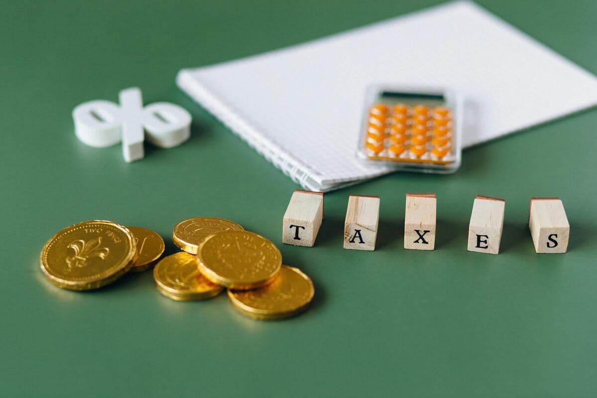 Financial objects on a green surface, representing taxes and calculations