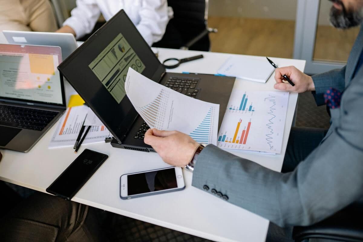 Overhead view of hands working with charts and computers in an office setting
